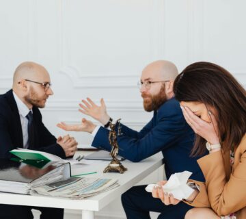 زن ناراحت در جلسه مشاوره حقوقی درباره نفقه با حضور وکیل و همسر در دفتر وکالت